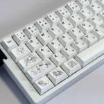 A collection of original minimalist anime PBT keycaps set for custom keyboards, showcasing their clean design, subtle graphics, and soft color palette.