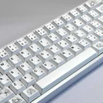 An artistic product gallery shot of the minimalist anime PBT keycaps set, highlighting their clean aesthetic, original subtle graphics, and soft colors.