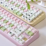A close-up view of delightful Apple Cat PBT dye-sub keycaps set, revealing their charming, durable artistry and soft colors from a distinct angle.