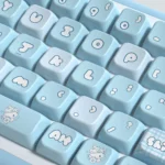 Close-up of adorable Aqua Kitten PBT MDA keycaps set from a playful angle, showcasing the calming aqua hues and whimsical kitten illustrations. Perfect for feline fans.