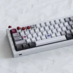 A premium Arcade Joystick & Button Keycaps, featuring sleek metallic finishes and miniature retro gaming icons displayed from multiple angles.