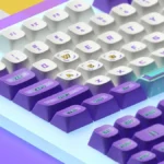 Vibrant retro arcade PBT keycaps set, viewed from an angle, highlighting detailed pixel art and classic 8-bit game graphics for a playful gaming setup.