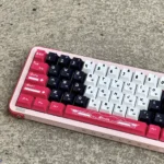 Arcee PBT keycap set from various angles, displaying the iconic Transformers theme. Vibrant pink, purple, and white dye-sub legends evoke nostalgic design.