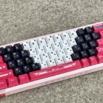 Arcee PBT keycap set shows iconic Transformers design with pink, purple, and white dye-sub legends from multiple angles, evoking nostalgia.