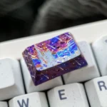 Ethereal purple starry sky artisan titanium keycap, handcrafted with shimmering stars and vibrant meteor trails against a deep cosmic expanse.