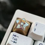 Close-up of the premium Asuka Langley Soryu titanium keycap, highlighting its polished finish and the iconic fiery star pentagon design.