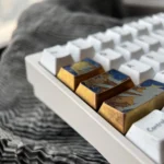 Gallery view of the premium Vibrant Asuka Titanium Keycap Set, showing intricate anime designs and metallic craftsmanship from various perspectives.