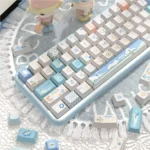 A vibrant PBT Dye-Sub Beach Summer Keycap Set, playfully showcasing the individual keycaps from a different angle with crisp blues, sandy design.