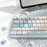 A vibrant PBT Dye-Sub Beach Summer Keycap Set from a playful angle, showcasing crisp blues and sandy evoking ocean waves and sunny beaches.