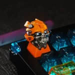 Iconic Transformers Bumblebee artisan keycap in a detailed view, highlighting its vibrant yellow/black design and translucent finish for stunning RGB.