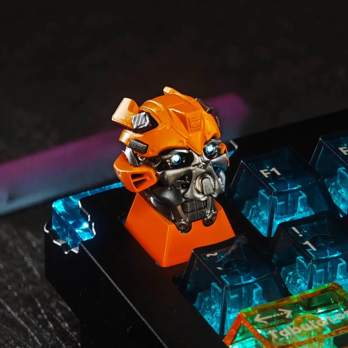 Iconic Transformers Bumblebee artisan keycap in a detailed view, highlighting its vibrant yellow/black design and translucent finish for stunning RGB.