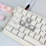 Close-up of a whimsical pink butterfly artisan keycap, showcasing its high-transparency 3D design with delicate heart accents for a dreamy keyboard.
