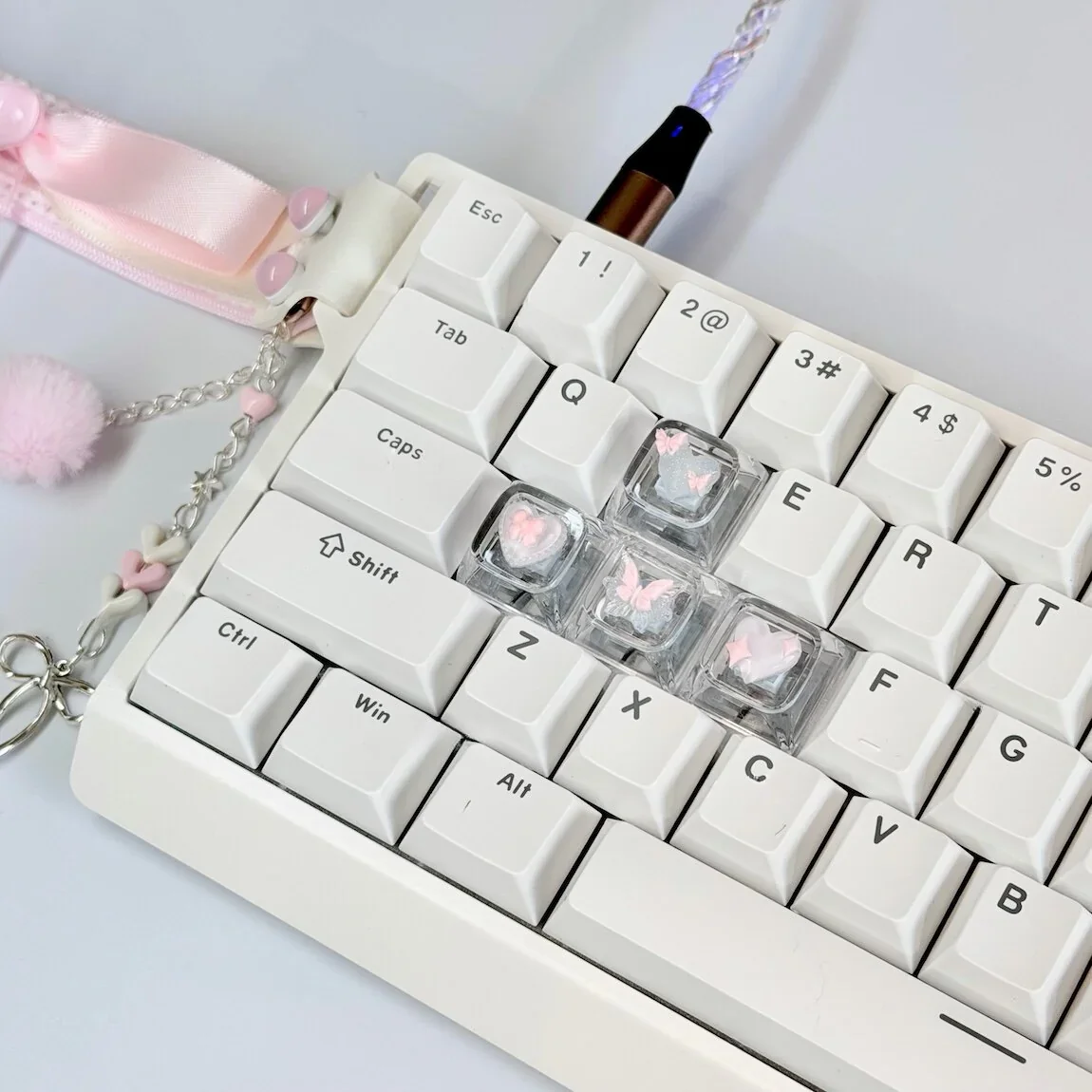 Close-up of a whimsical pink butterfly artisan keycap, showcasing its high-transparency 3D design with delicate heart accents for a dreamy keyboard.