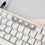 Delicate high-transparency 3D pink butterfly artisan keycaps, part of a whimsical WASD set, showcasing their dreamy aesthetic and intricate details.