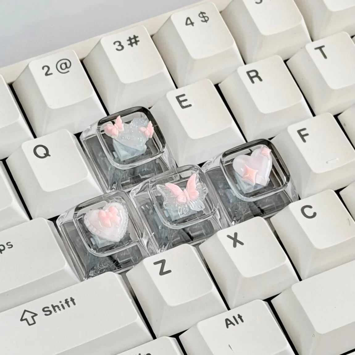 Whimsical pink butterfly keycaps, an artisan WASD set showcasing high-transparency 3D butterflies and delicate hearts for a dreamy keyboard.