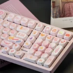 A vibrant close-up of the Cardcaptor Sakura PBT MOA keycaps set, displaying pastel colors, sparkling stars, and iconic magical anime motifs from a character design.