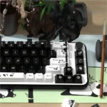 Charming Panda PBT Dye-Sub Keycaps Set from a playful side angle, revealing the minimalist black and white panda design for keyboards.