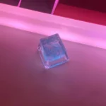 Playful close-up of a vibrant, translucent Crushed Ice Keycap, handcrafted with sparkling crystal filling, emphasizing its refreshing texture.