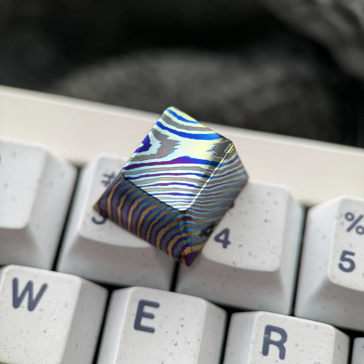 Unique handcrafted Damascus titanium ESC keycap gallery, displaying intricate patterns and iridescent hues from various premium angles.