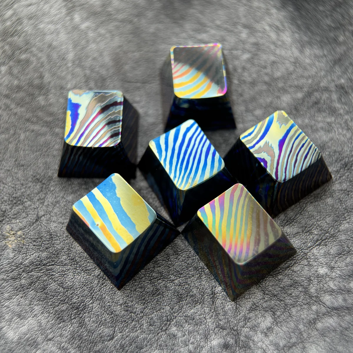 Close-up of a unique handcrafted Damascus Titanium ESC keycap, showcasing its intricate, iridescent patterns and premium modern aesthetic.