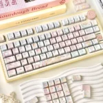 A collection of Dreamy Girl's Worries Series Keycap Set for custom keyboards, showcasing their whimsical pastel hues from various playful angles, perfect for gamers.