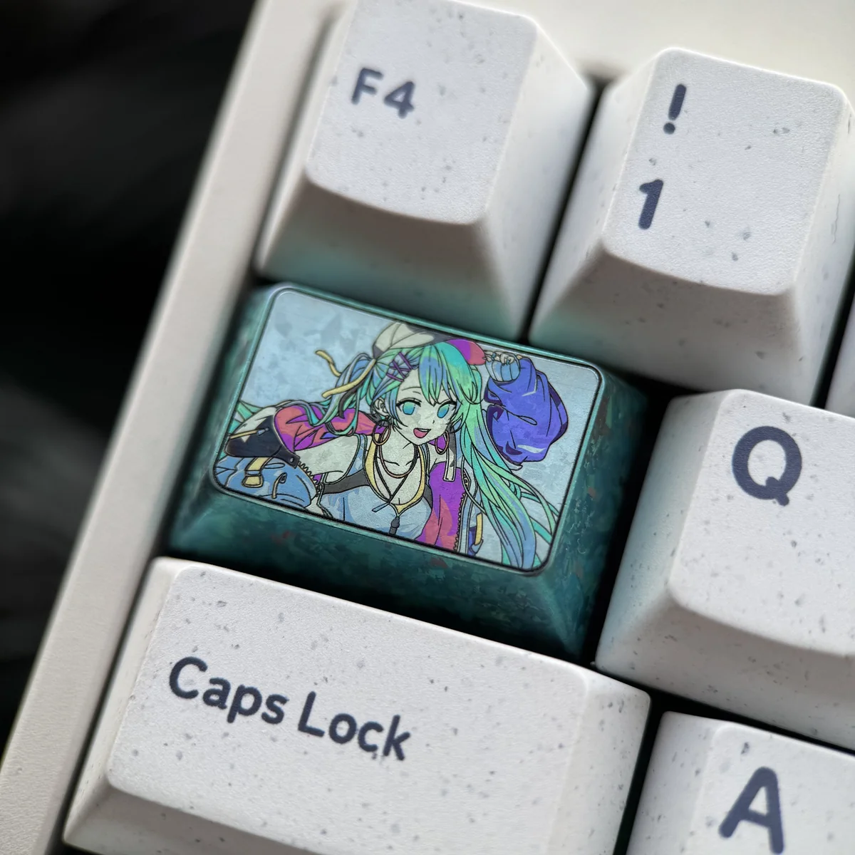 Close-up of the Hatsune Miku 1.5U Tab Titanium Artisan Keycap, highlighting its iconic design and durable metallic finish from an angled view.