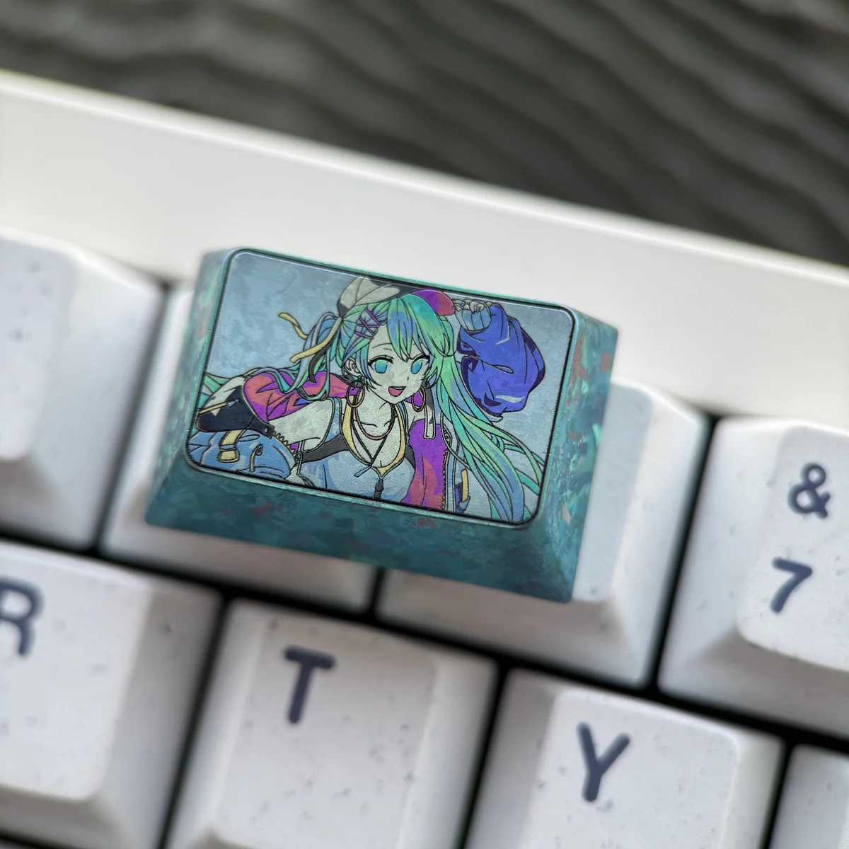 Detailed shot of the premium Hatsune Miku 1.5U Tab titanium artisan keycap, showcasing its iconic design and sleek, durable metallic finish.
