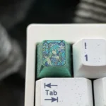 Artistic Iconic Hatsune Miku Titanium Artisan ESC Keycap, featuring vibrant Miku design and a dynamic broken glass effect on lustrous titanium.