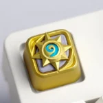 Close-up views of the iconic golden Hearthstone resin ESC keycap, showcasing its intricate artisan design and rich texture from multiple angles.