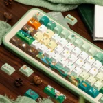 Close-up of JX3 Medicine Keycaps set, showcasing whimsical botanical forest designs and earthy tones from multiple angles. Exclusive JX3 Medicine Sect design.