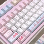 Artistic JX3 Qi Xiu pixel keycaps set, featuring exclusive JX Online 3 clan art. Charming pixel designs are seen from multiple angles, perfect for gaming setup.