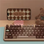 A close-up view of the adorable Lucky Bear PBT gradient keycaps set, showcasing their warm brown hues and whimsical bear motif from multiple angles.