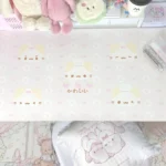 A detailed view of the extra-large whimsical marshmallow cat desk mat in soft pastel pink, highlighting its cute, dreamy design from a new angle.