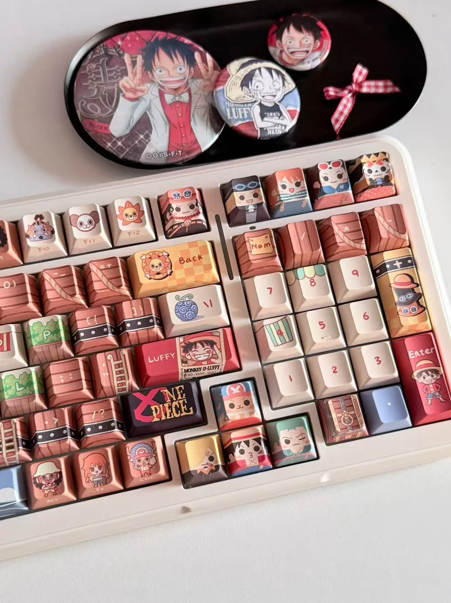 Detailed gallery views of the complete One Piece Straw Hat PBT keycap set. Vibrant, iconic anime characters and symbols from playful angles.