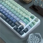 Close-up of Serene Wind artistic dye-sub PBT keycap set, showcasing tranquil cloud motifs and soothing colors from multiple angles for serene typing.