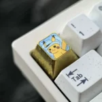 Collectible titanium Pikachu artisan keycap with a charming hat, meticulously crafted and shown from multiple angles. Highlights premium detail.