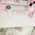 Playful pink desk mat, from a fresh perspective, showcasing its unique fish cake design and soft pastel colors, adding whimsical charm to your workspace.