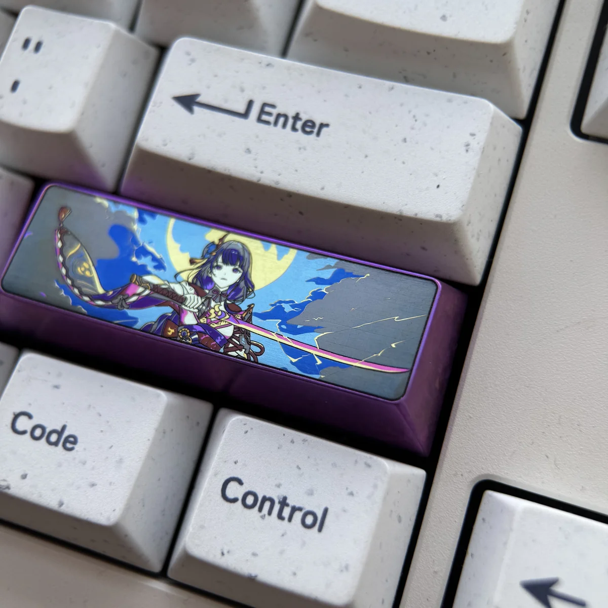 Majestic titanium Raiden Shogun keycap for Genshin Impact, displayed from various angles, highlighting its premium anodized finish and intricate Electro design.