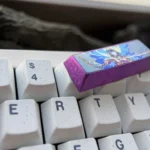 Majestic titanium Raiden Shogun keycap from Genshin Impact, showcasing its premium anodized finish and intricate Electro Archon design from various angles.