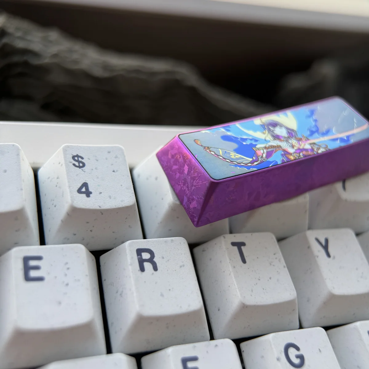Majestic titanium Raiden Shogun keycap from Genshin Impact, showcasing its premium anodized finish and intricate Electro Archon design from various angles.