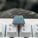 The Van Gogh Starry Night Titanium ESC keycap, exquisitely crafted with swirling cosmic blues and yellows, displayed from various angles to reveal it.