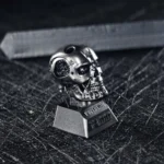 Close-up views of the iconic Terminator T800 artisan resin keycap, showcasing its gritty cybernetic details, metallic finishes, and premium craftsmanship design.