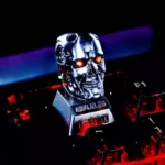 Close-up of the iconic Terminator T800 artisan resin keycap, showcasing its gritty cybernetic details and metallic finish from multiple angles.