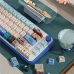 Close-up of Titanic PBT Cherry profile keycaps set, showcasing intricate vintage ship and iceberg designs on deep blue, evoking a nostalgic ocean voyage.