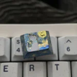 Angled view of a handcrafted Mystical Cat Titanium Artisan Keycap, showcasing its shimmering celestial cat design against a starry night sky.