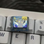 Detailed handcrafted Mystical Cat Titanium Artisan Keycap, highlighting its shimmering finish and celestial cat silhouette on a starry night sky.