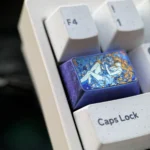 This premium titanium Asuka Evangelion 1.5U Tab keycap is presented from a striking angle, showcasing its vibrant anime design, reflective finish.