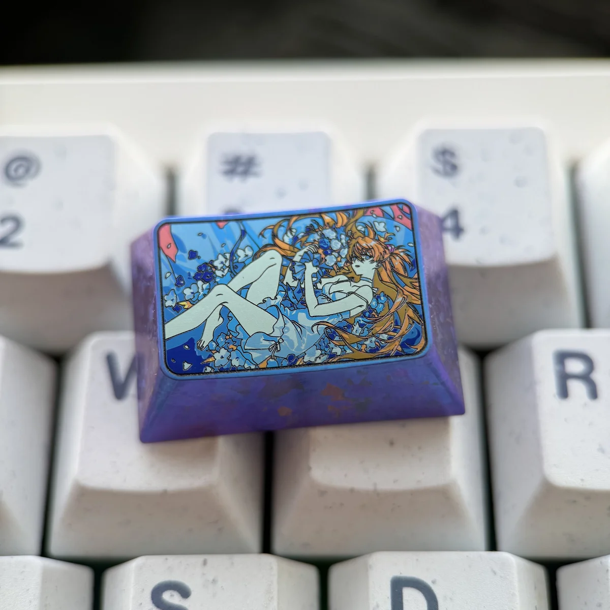 Detailed view of the premium Titanium Asuka Keycap, an artisan Evangelion 1.5U Tab. Its vibrant anime character and durable, reflective titanium.