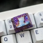 Handcrafted artisan titanium keycap from multiple angles, showcasing its shimmering cosmic purple starry sky design and premium metallic finish.