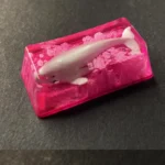 Handcrafted translucent whale fall keycap, multiple angles. Reveals unique deep-sea diorama, serene luminescence, and exquisite organic details.